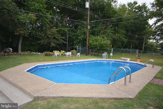 view of swimming pool featuring a diving board and a yard