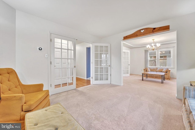 living area with beamed ceiling, carpet, a notable chandelier, and french doors