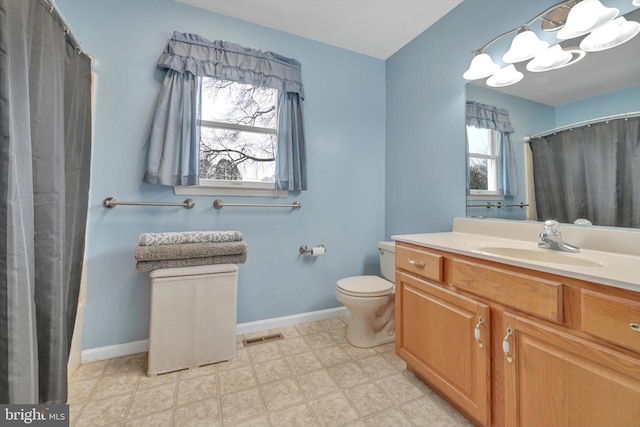 bathroom with toilet, plenty of natural light, and vanity