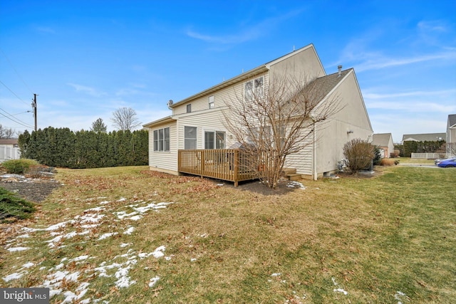 back of house featuring a wooden deck and a yard