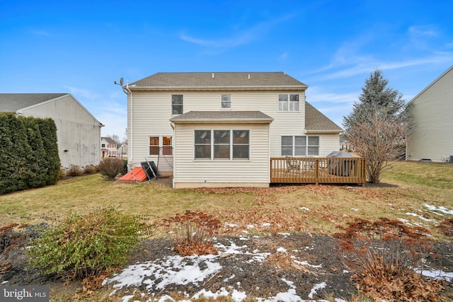 rear view of property with a deck and a yard