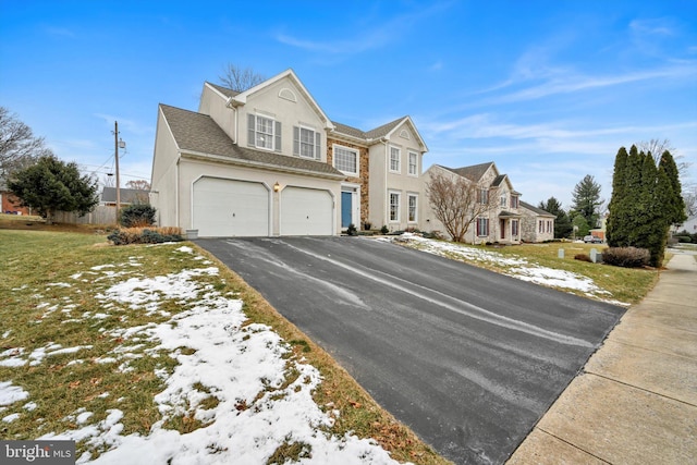 view of front of home with a garage and a yard