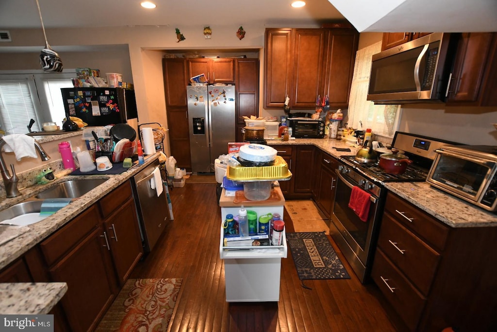 5211 Bosworth Ave, Baltimore, MD 21207 - kitchen with stainless steel appliances, light stone counters, wood finished floors, recessed lighting, and hanging light fixtures