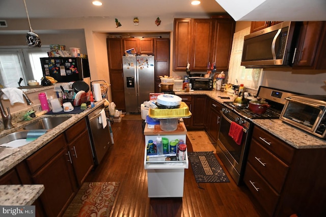 5211 Bosworth Ave, Baltimore, MD 21207 - kitchen with stainless steel appliances, light stone counters, wood finished floors, recessed lighting, and hanging light fixtures