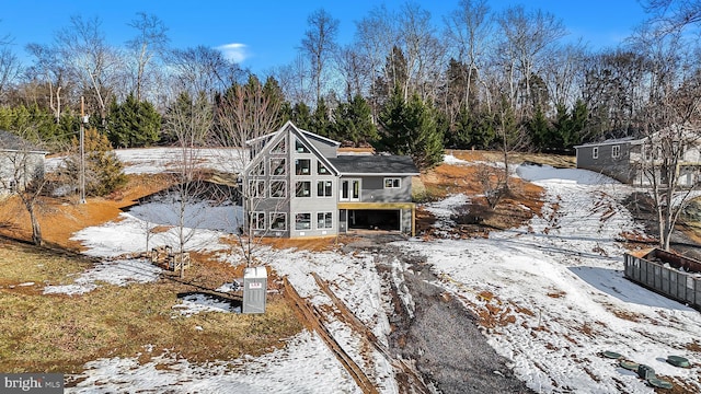 snow covered property with a garage