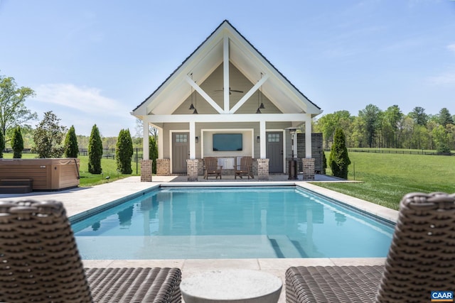 view of swimming pool featuring a hot tub, a patio, ceiling fan, a yard, and an outdoor structure