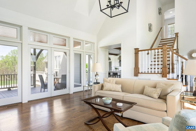 living room featuring a healthy amount of sunlight, dark wood-type flooring, high vaulted ceiling, and french doors