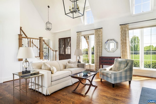 living room featuring a high ceiling, an inviting chandelier, and dark hardwood / wood-style floors