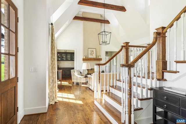 foyer entrance featuring high vaulted ceiling, beam ceiling, and wood-type flooring