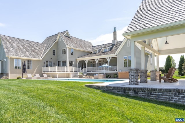 rear view of house with a lawn and a patio