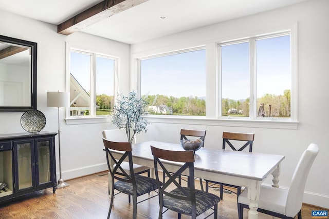 dining room with hardwood / wood-style flooring and beamed ceiling