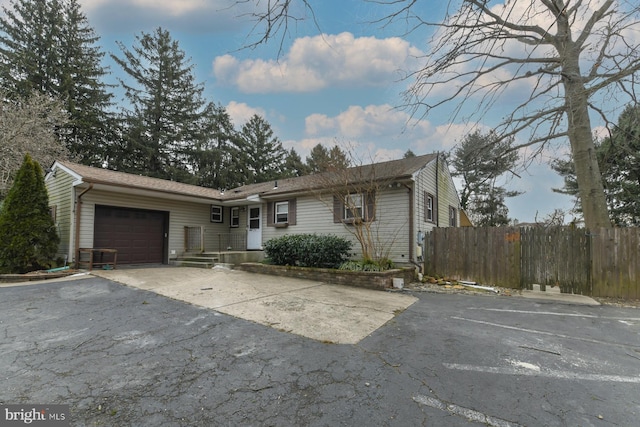 ranch-style house with a garage and central AC unit