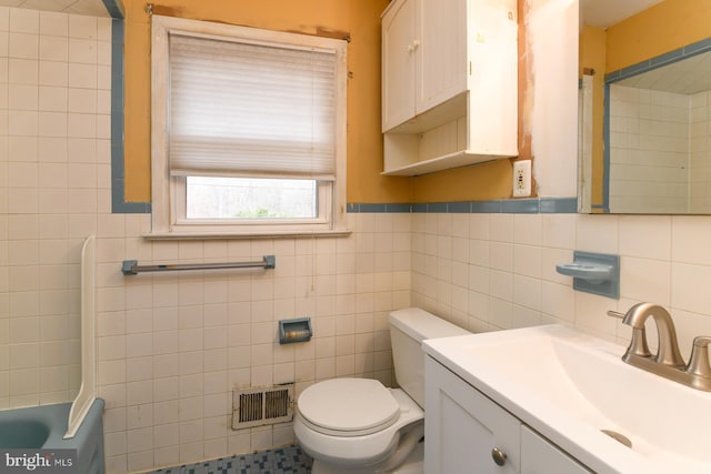 bathroom with tile walls, toilet, and vanity