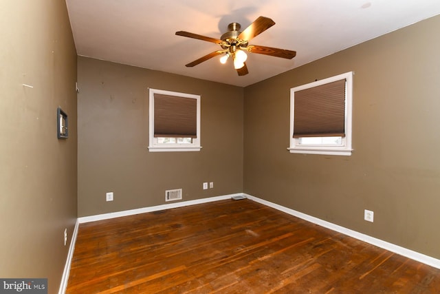 empty room with ceiling fan and dark hardwood / wood-style floors