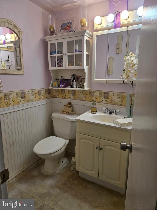 bathroom featuring toilet, tile patterned floors, and vanity