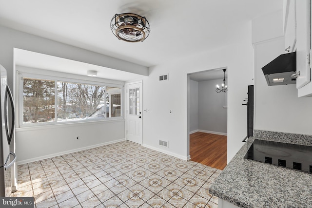 tiled entrance foyer featuring a notable chandelier