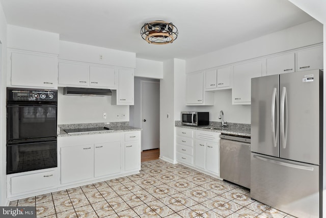 kitchen with black appliances, white cabinetry, and light stone countertops