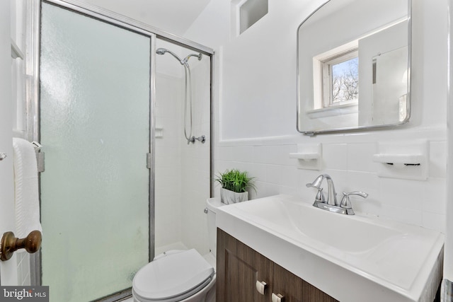 bathroom featuring toilet, tile walls, an enclosed shower, and vanity