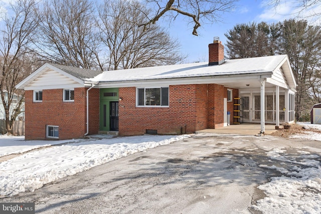 snow covered house with a sunroom