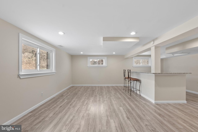 basement with light hardwood / wood-style flooring