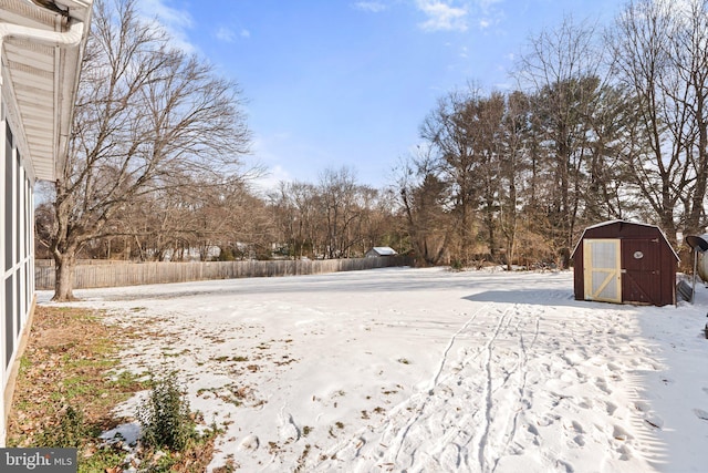 yard covered in snow with a storage unit