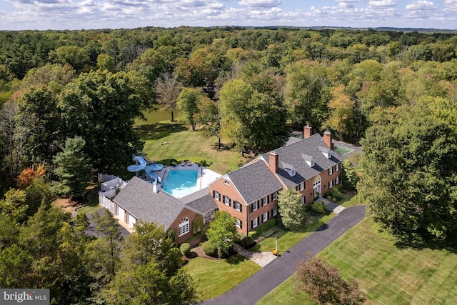 birds eye view of property featuring a view of trees