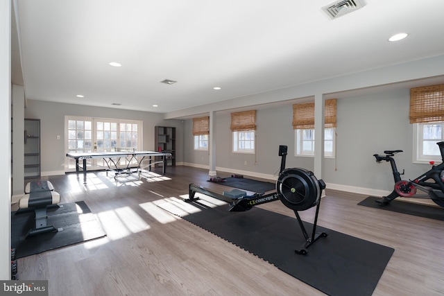 workout room with visible vents, a healthy amount of sunlight, baseboards, and wood finished floors