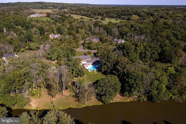 birds eye view of property with a view of trees and a water view