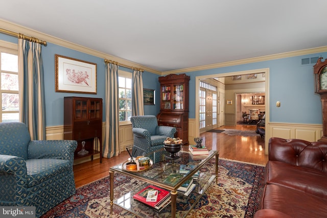 living room with wood finished floors, visible vents, french doors, and wainscoting