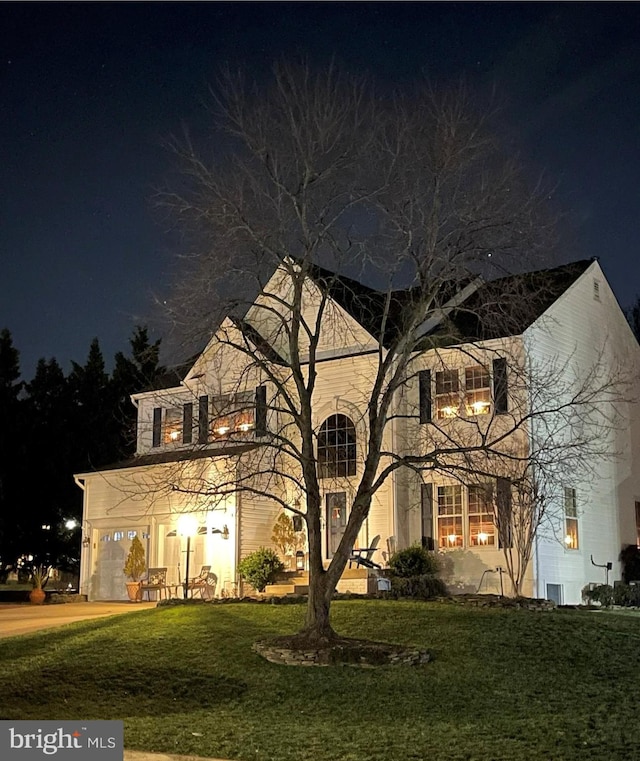 traditional-style house featuring a garage and a yard