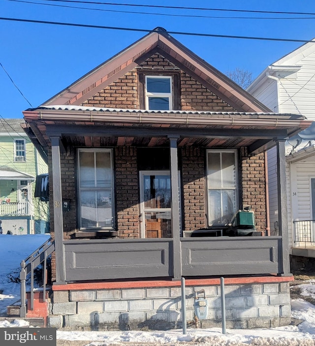 view of snowy exterior with covered porch