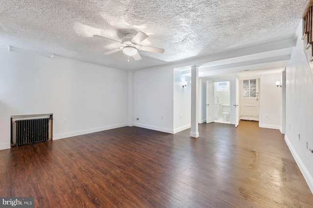 unfurnished living room featuring ceiling fan, a textured ceiling, and dark hardwood / wood-style flooring