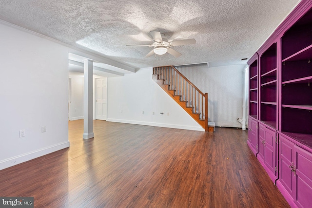 unfurnished living room featuring ceiling fan, dark hardwood / wood-style flooring, and a textured ceiling