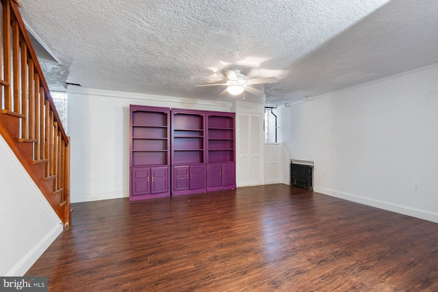 unfurnished living room with ceiling fan, dark hardwood / wood-style flooring, a textured ceiling, and a wealth of natural light