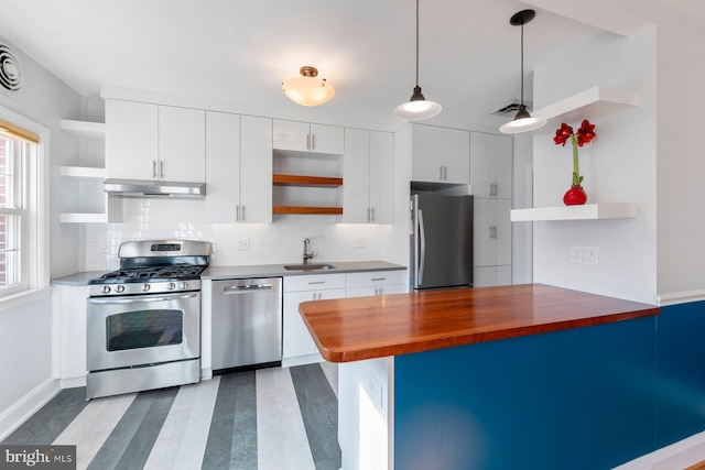 kitchen featuring sink, white cabinetry, hanging light fixtures, stainless steel appliances, and wood counters