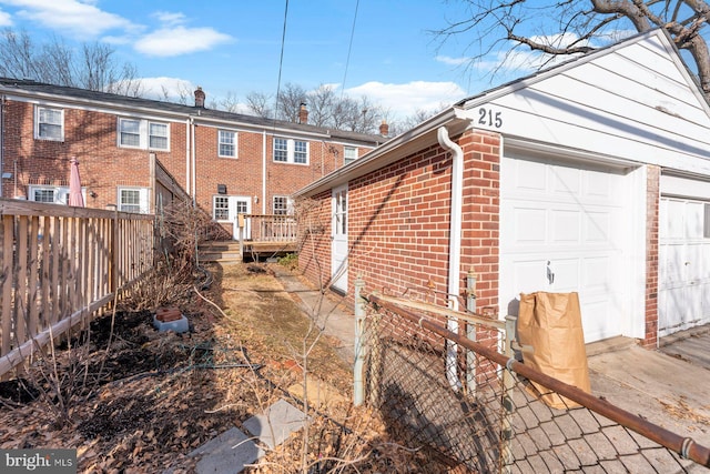 view of side of home with a wooden deck and a garage