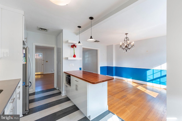 kitchen with stainless steel appliances, white cabinetry, dark hardwood / wood-style floors, and wooden counters