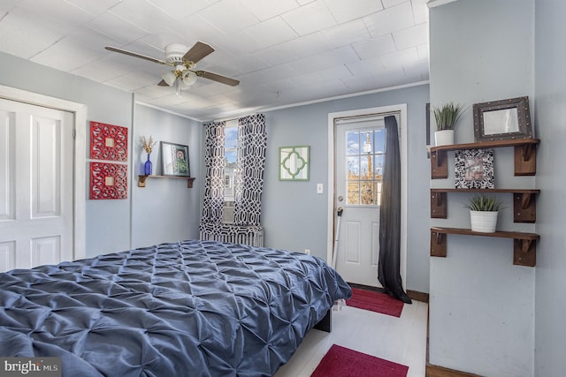 bedroom with ceiling fan and crown molding