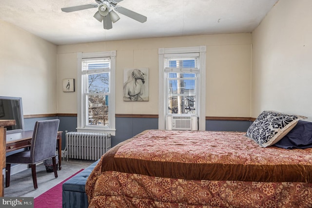 bedroom featuring ceiling fan, cooling unit, radiator heating unit, and carpet floors