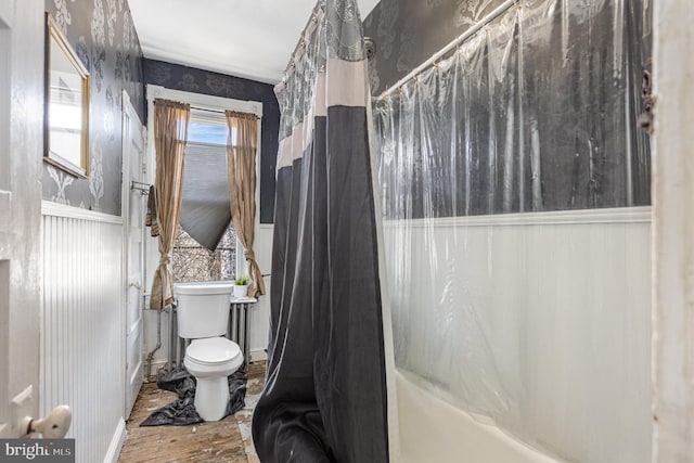 bathroom featuring toilet, shower / bath combination with curtain, and hardwood / wood-style floors