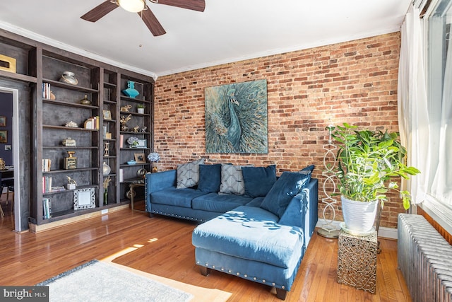 living room with wood-type flooring, brick wall, and radiator heating unit