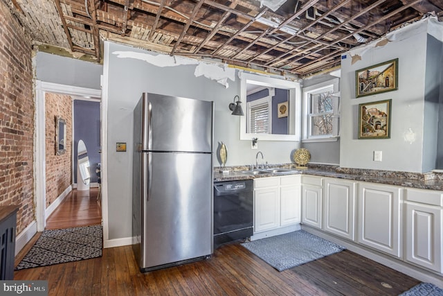 kitchen featuring sink, brick wall, stainless steel fridge, and dishwasher