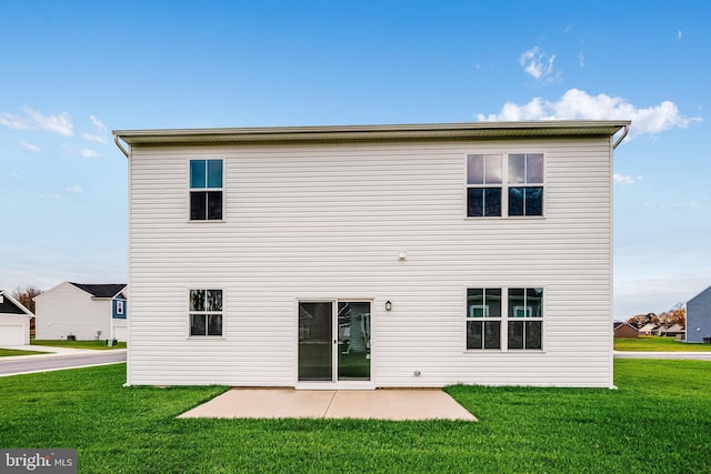 back of property with a lawn and a patio area