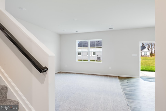 empty room with wood-type flooring and a wealth of natural light