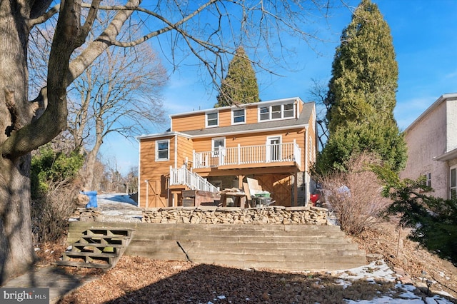 rear view of property featuring a wooden deck