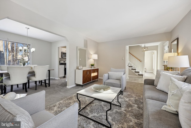 carpeted living room featuring a chandelier