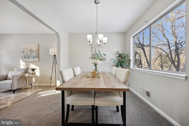 dining area with a chandelier and carpet floors