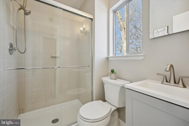 bathroom featuring toilet, walk in shower, and vanity