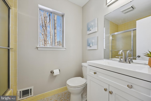 bathroom with toilet, vanity, and tile patterned flooring