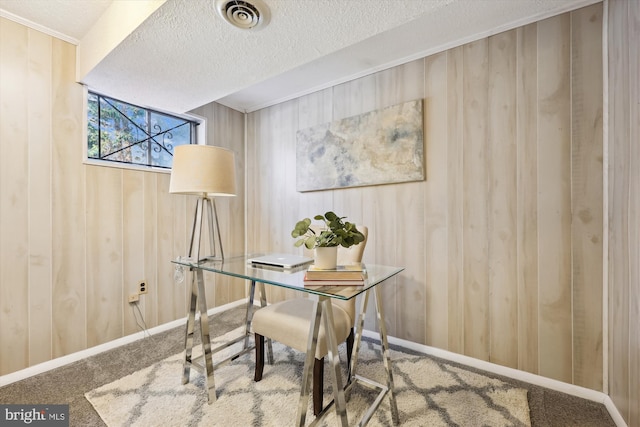 office with carpet floors, a textured ceiling, and wood walls